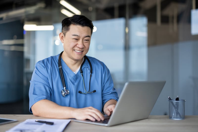 smiling physician on computer